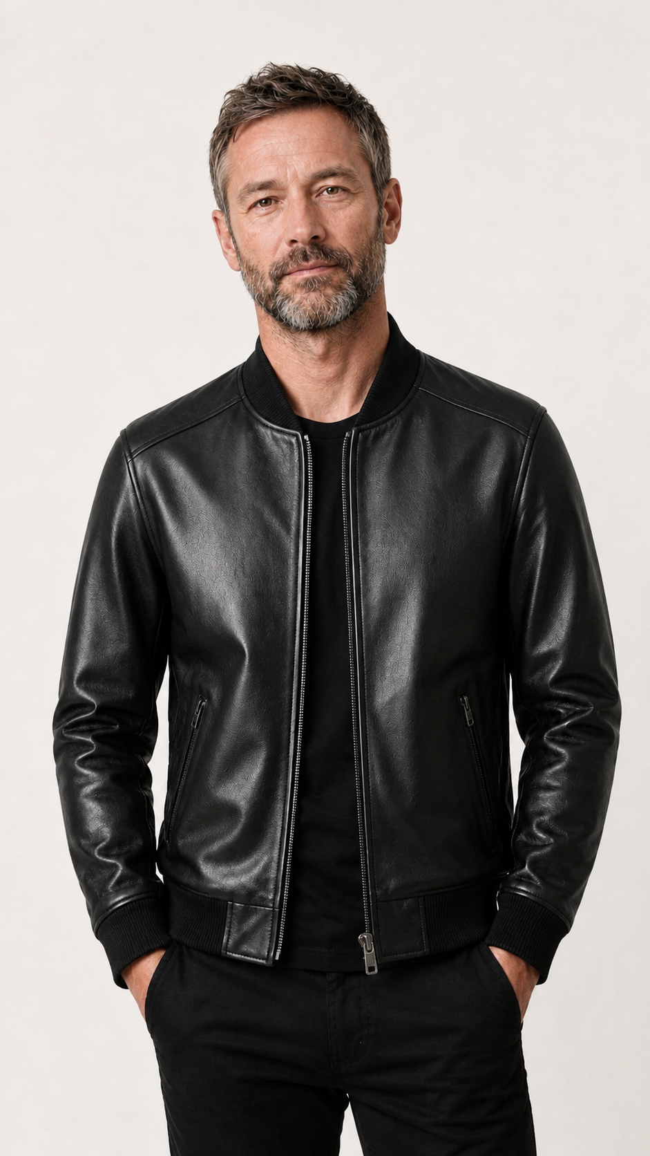 Man standing in the black sheepskin bomber jacket over a dark tee — British model